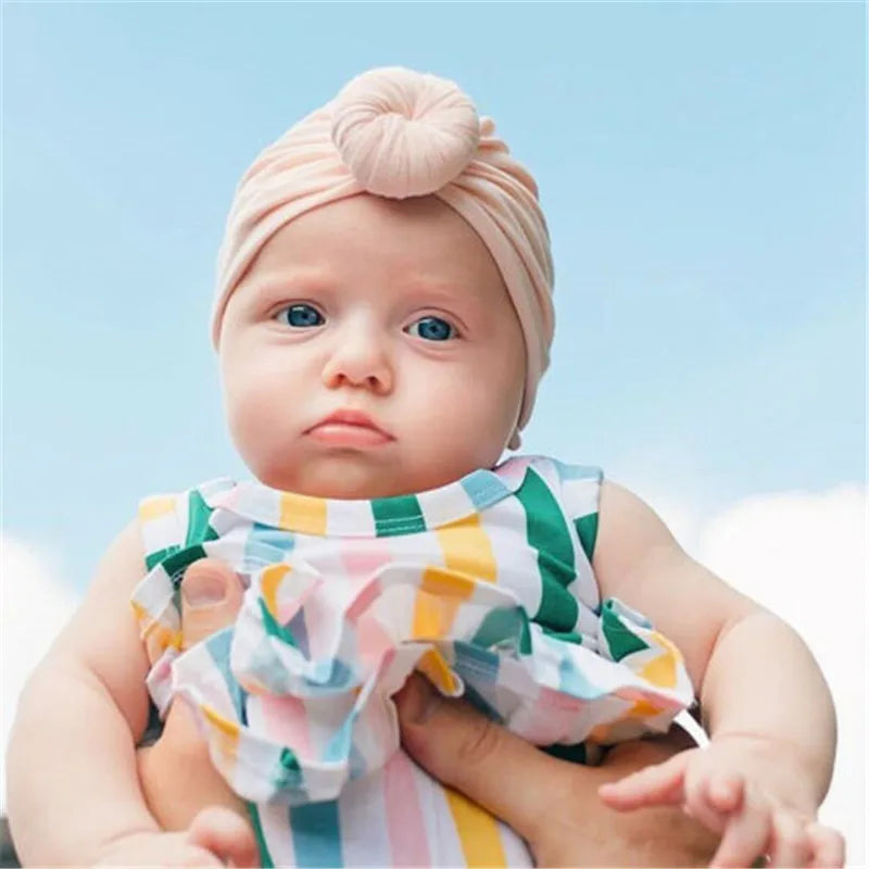 Baby girl wearing a soft top knot turban in beige