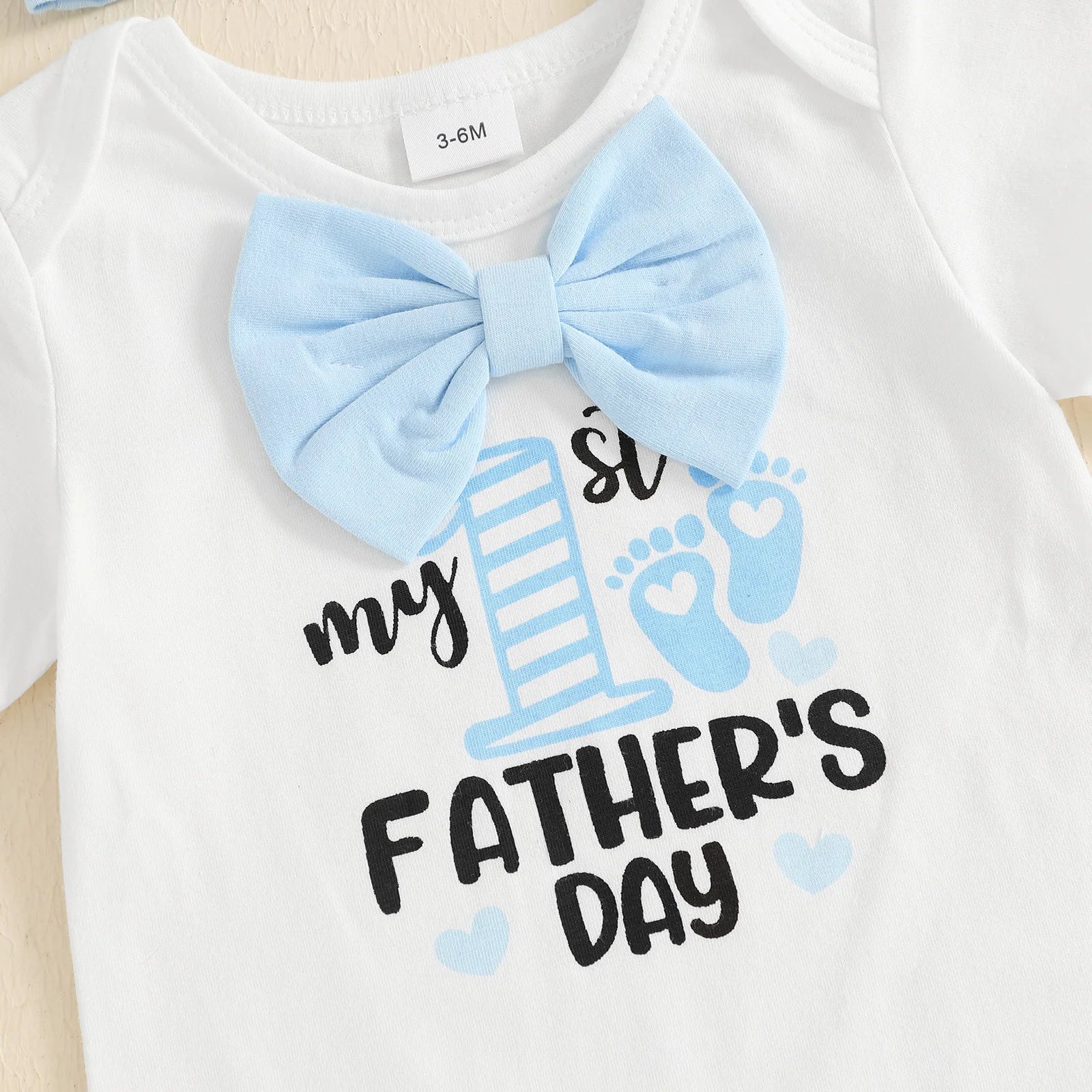 White bodysuit with blue bow tie and 'My 1st Father's Day' print for baby's first Father's Day celebration.