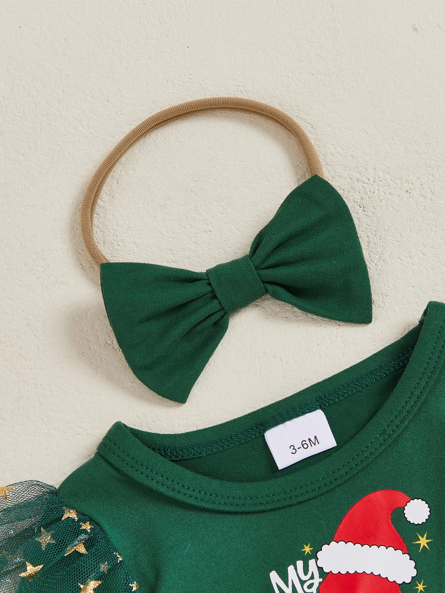Baby girl Christmas dress accessories, featuring a green bow hairband and festive dress. Perfect for a first Christmas outfit.