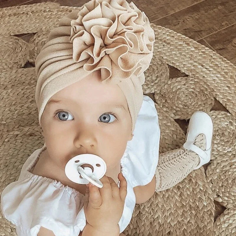 Baby girl wearing a beige flower turban from Lulu Babe