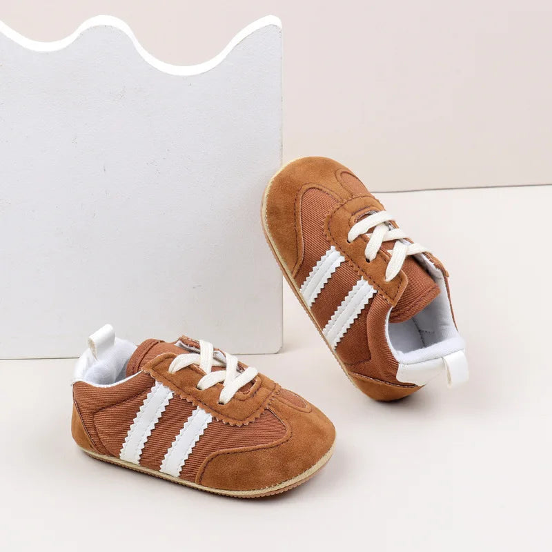 Classic stripe baby sneakers in brown with white details, perfect for stylish tiny feet aged 0-18 months.