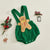 Gingerbread man romper in vibrant green corduroy, ideal Christmas baby outfit for festive celebrations.