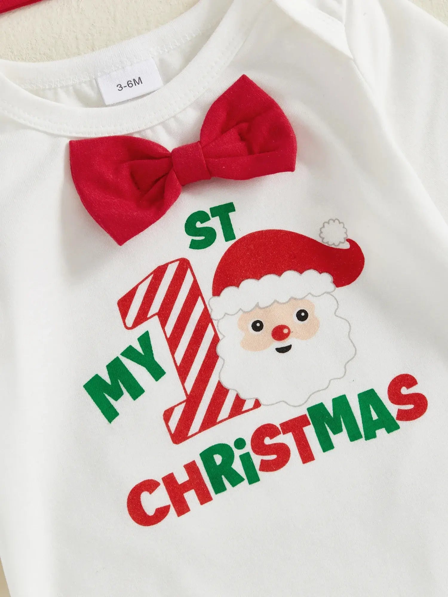 Soft baby bodysuit for Christmas with festive 'My 1st Christmas' print and red bow, perfect for baby boys.