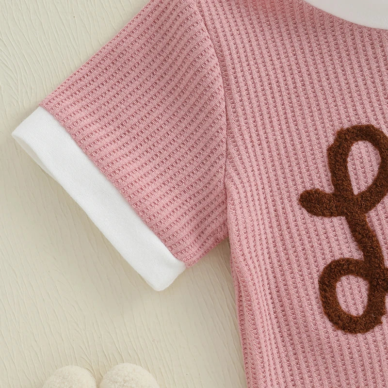 Close-up of the Lil Sis Pink Shorts Set top featuring pink waffle-texture and soft white trim.