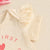 Close-up of the ruffle sleeve of a cream bodysuit from the My First Father's Day Ruffle Set.