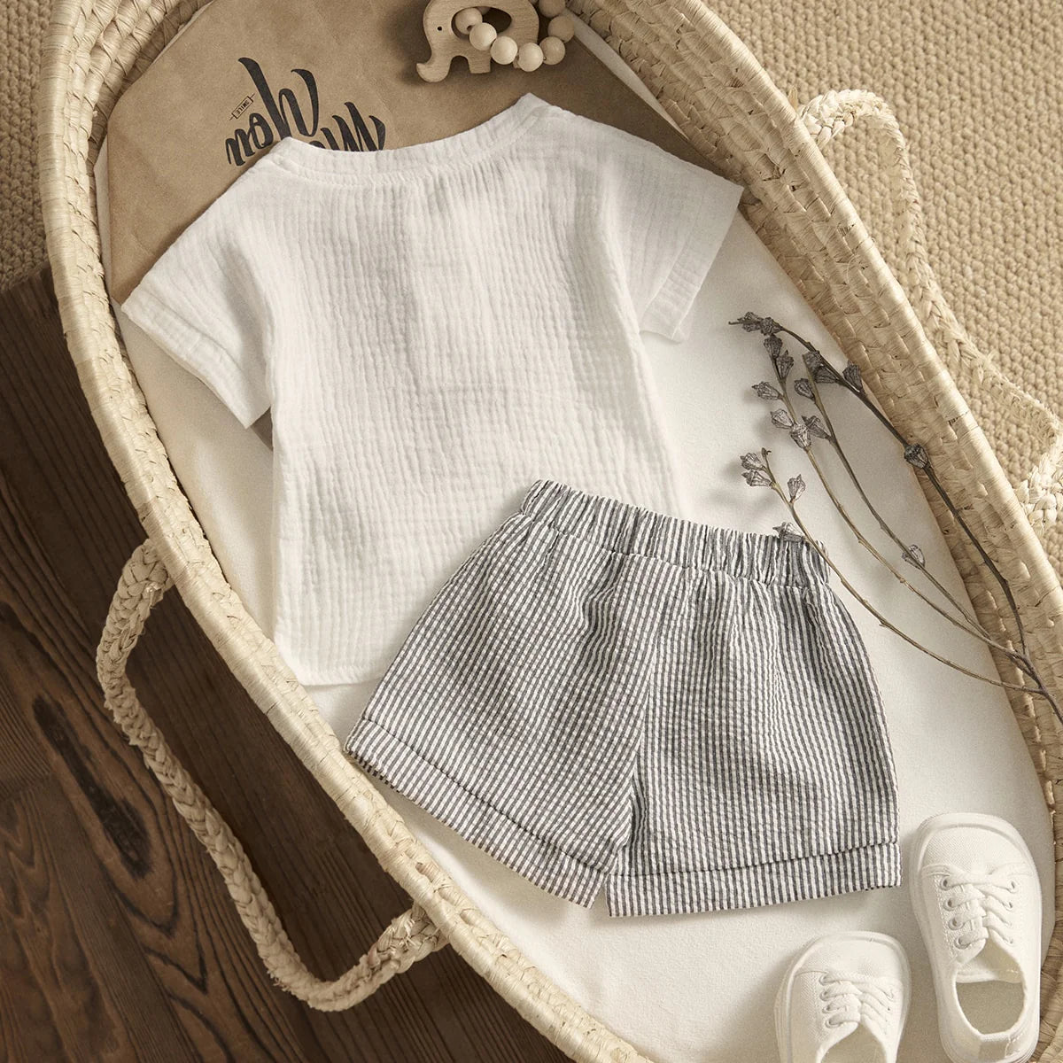 Flatlay of Arlo baby muslin outfit in bassinet showing the reverse side