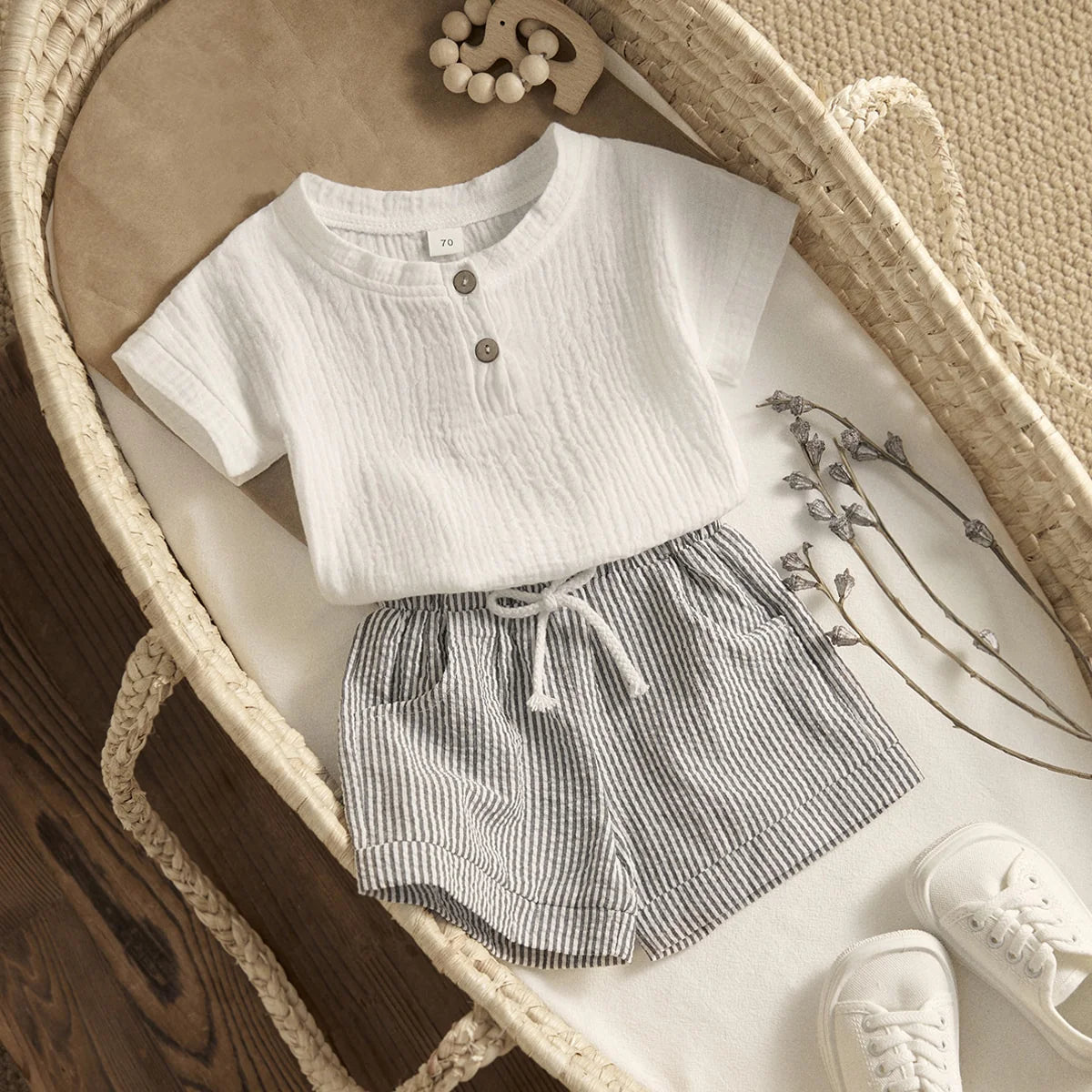 Flatlay of Arlo baby muslin outfit in bassinet