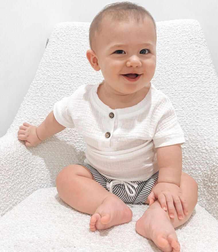 Baby boy wearing our Arlo muslin summer set: white muslin top and pinstripe shorts