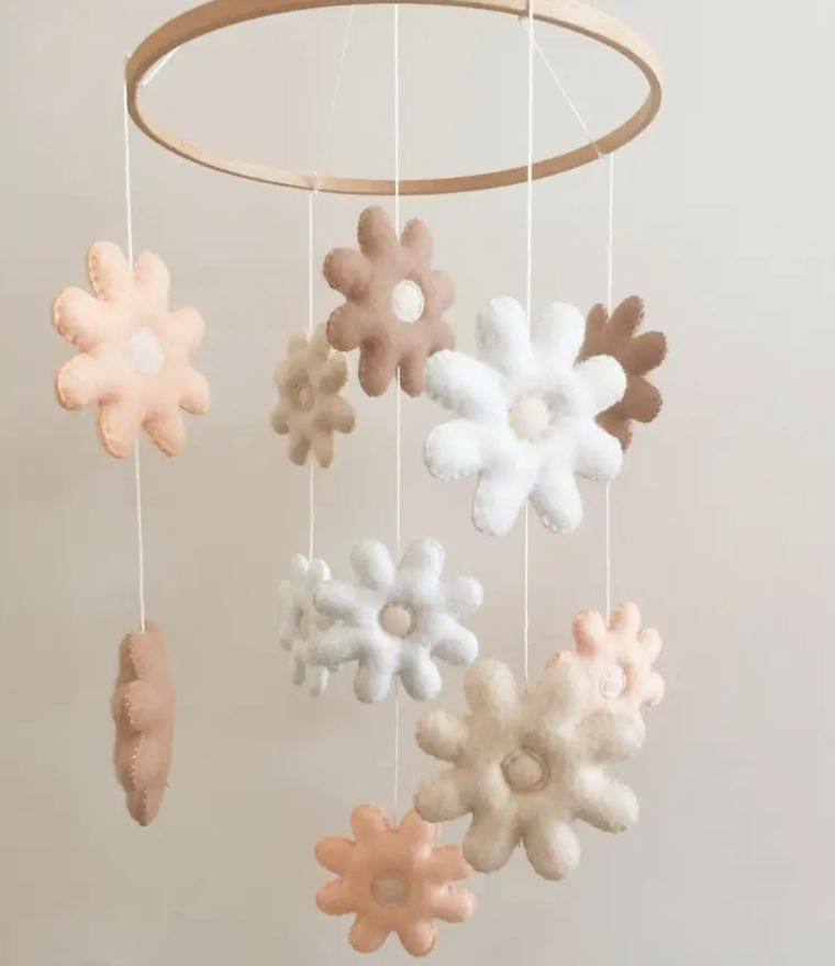 Daisy baby cot mobile featuring soft felt flowers in neutral tones, perfect for a nursery or baby room decor.