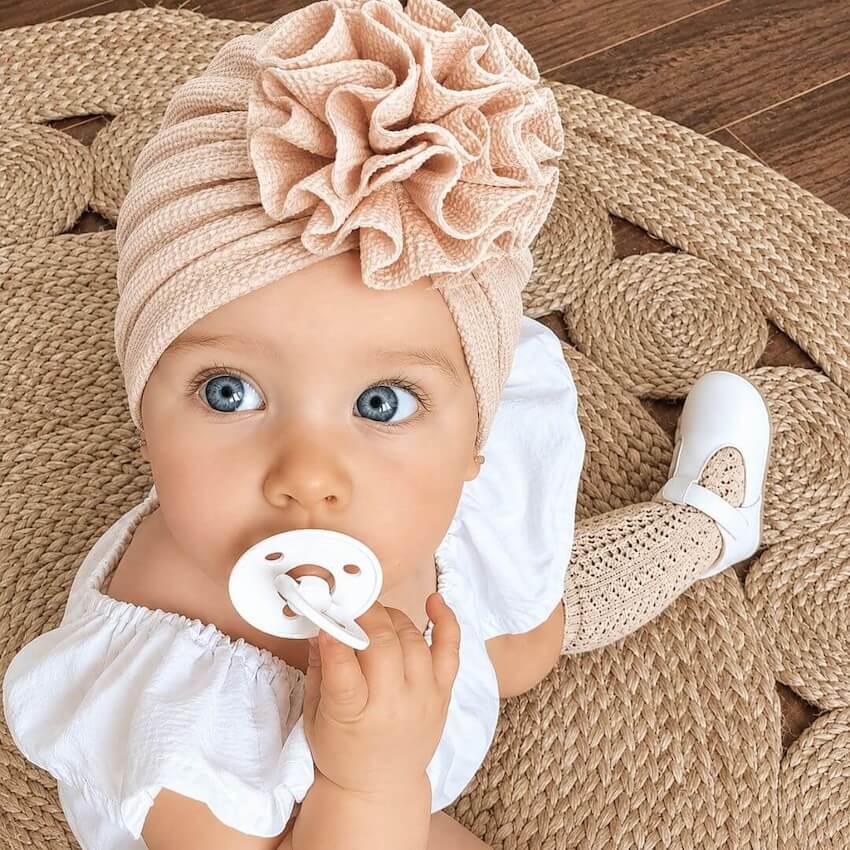 Baby girl wearing a beige flower turban from Lulu Babe