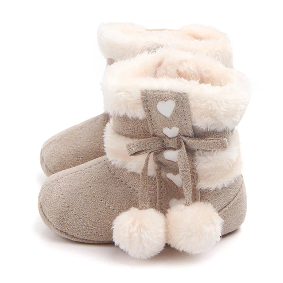 Adorable heart slipper boots for babies with plush lining and pom poms, perfect for winter warmth - fawn colour