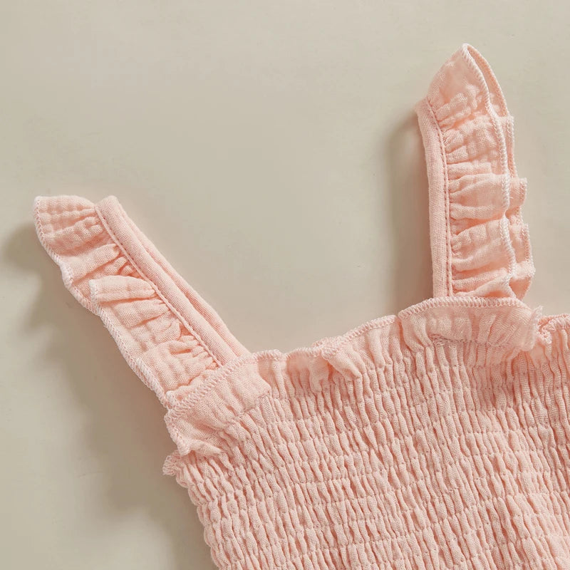 Close-up of blush pink baby girl summer jumpsuit