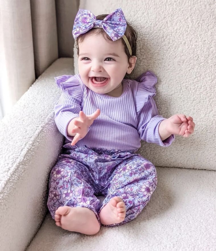 Smiling baby wearing Floral Flutter Baby Girl Outfit in purple from Lulu Babe