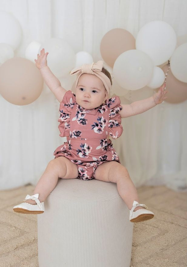 Baby girl wearing Matilda floral romper in rose pink
