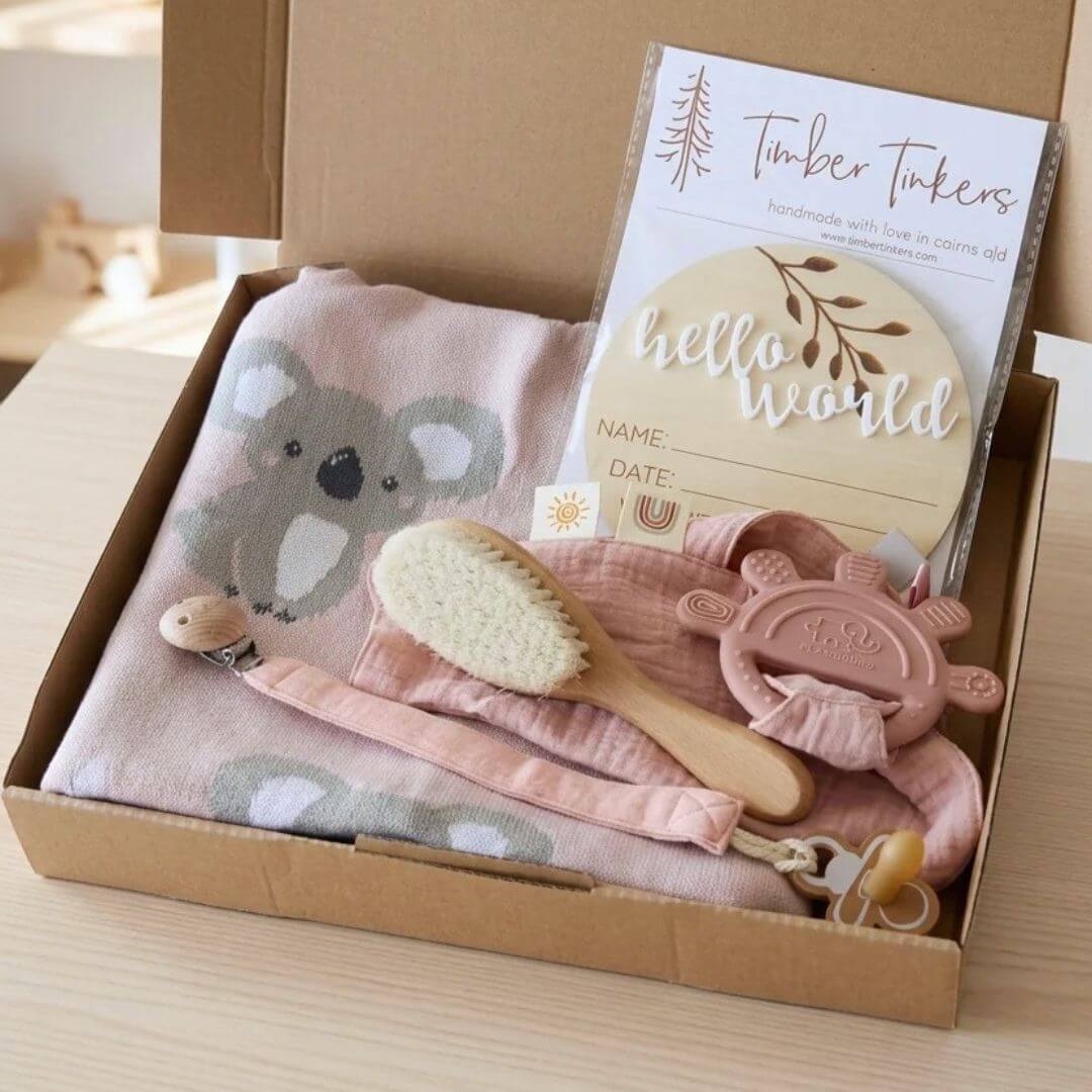 Baby Gift Box – Pink Koala open flat lay showing koala blanket, muslin comforter, pacifier clip, wooden brush and Hello World disc