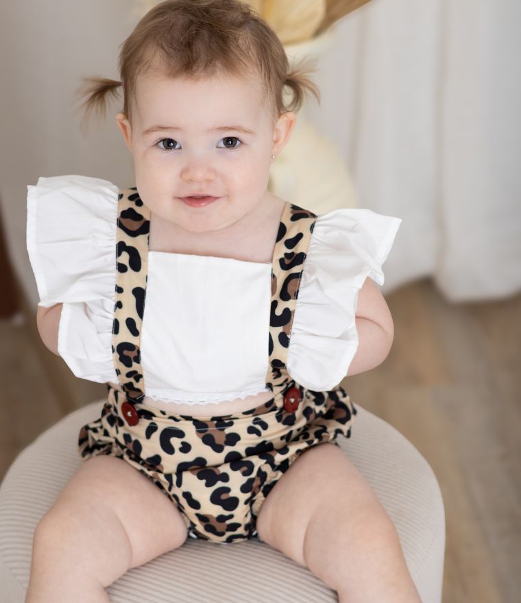 Baby girl wearing leopard pinafore romper