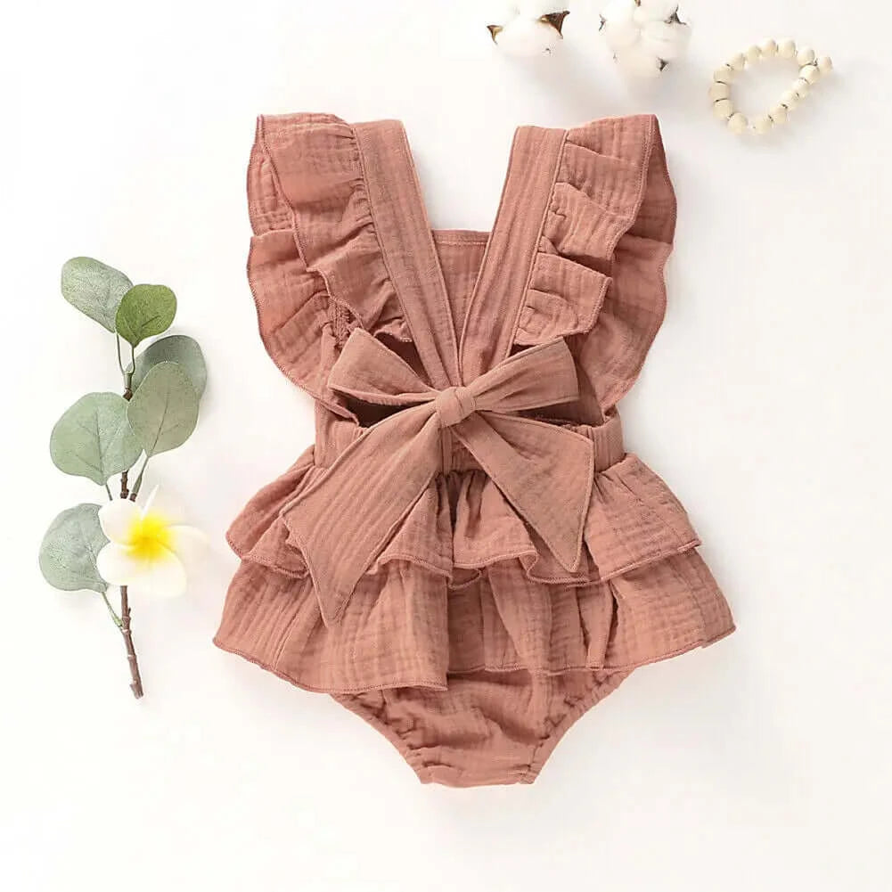 Jennifer Ruffle Baby Girl Romper styled flat lay showing the back view