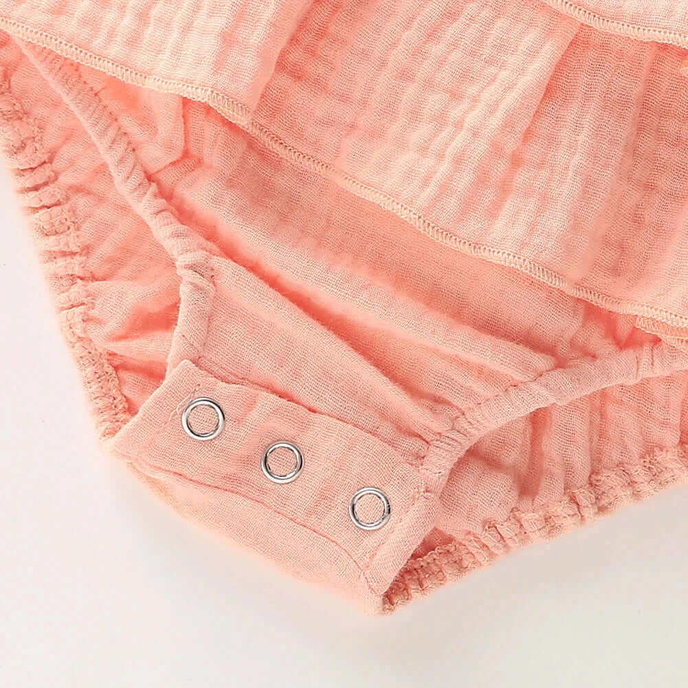 Closeup of Jennifer Ruffle Baby Girl Romper in pink showing snap closure
