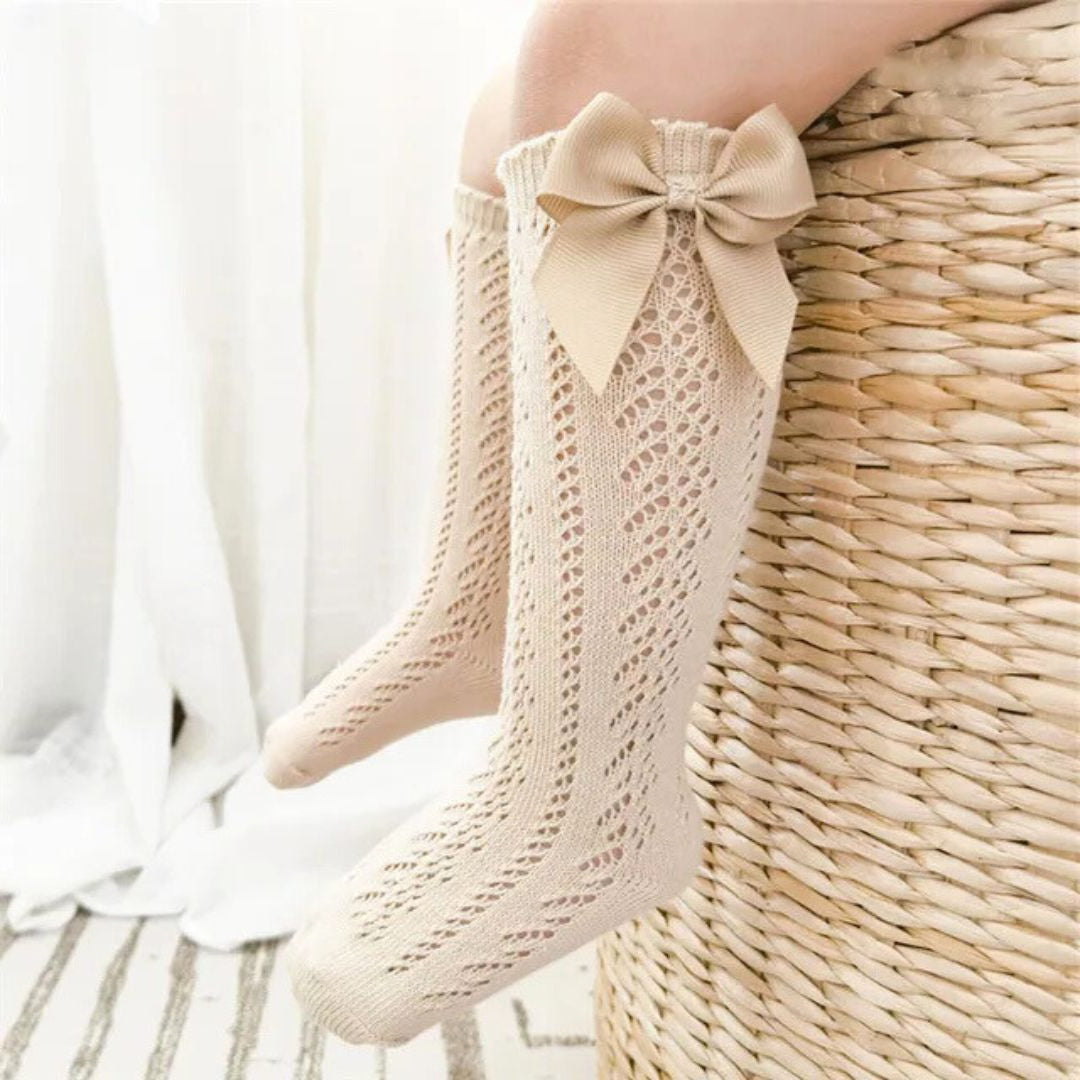 Lifestyle image of baby girl lace knee high socks in beige