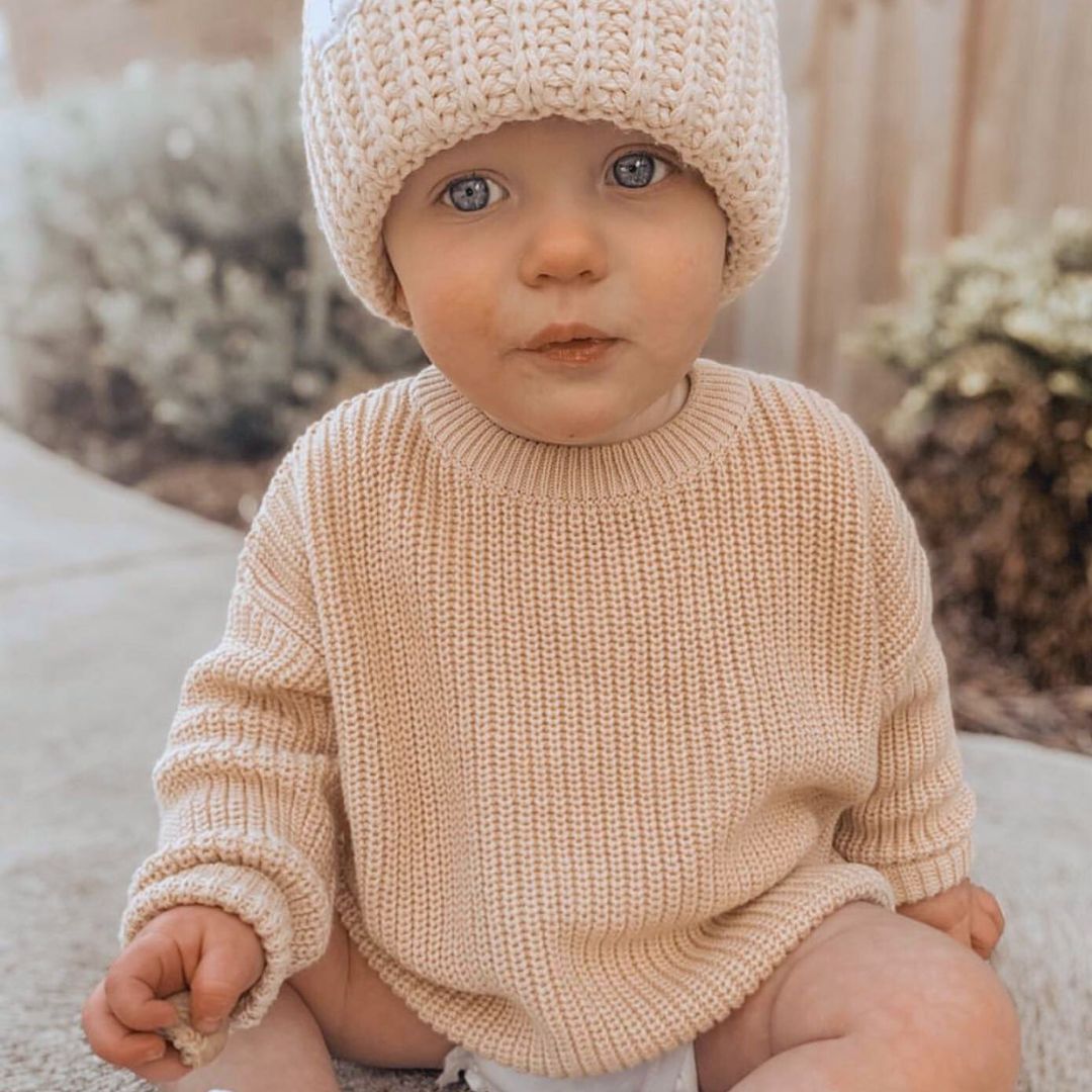 Cute baby boy wearing our chunky knitted jumper in beige