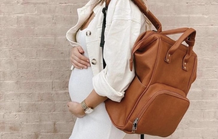 Pregnant woman carrying a stylish vegan leather nappy backpack from Lulu Babe