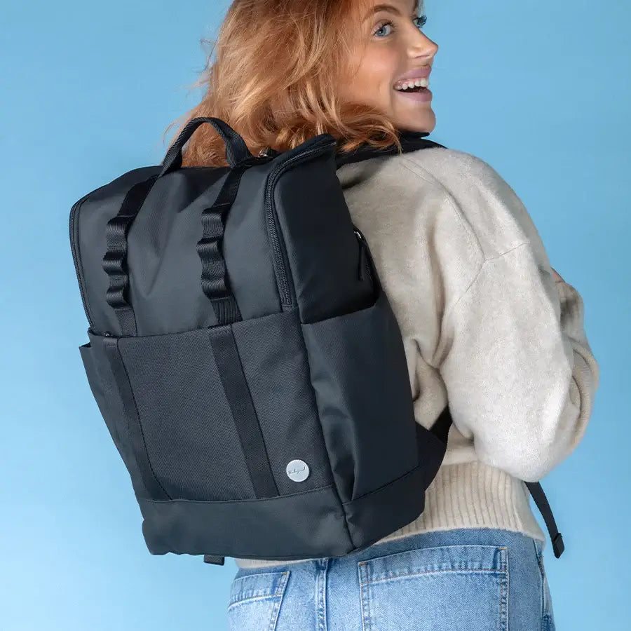 Mum wearing the black Babymel Finn nappy backpack, showcasing its stylish design.