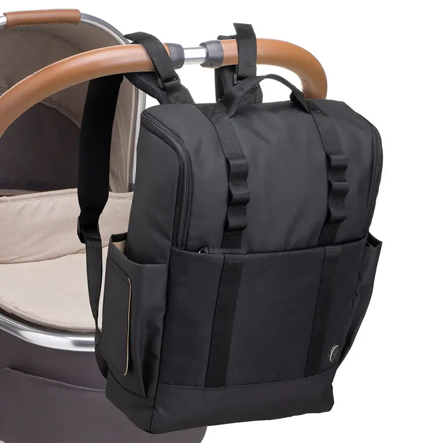 Babymel Finn nappy backpack in black attached to a pram using the integrated stroller straps.