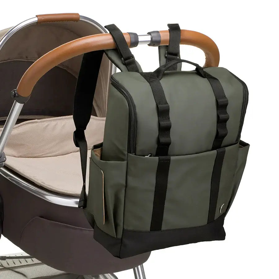 Babymel Finn nappy backpack in olive green, attached to a pram using the integrated stroller straps.