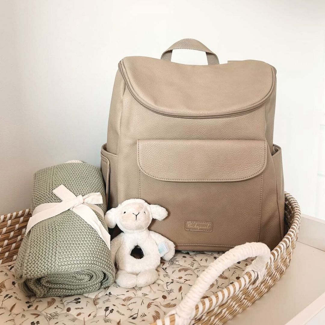 Babymel Lennox nappy backpack in oat, displayed in baby nursery