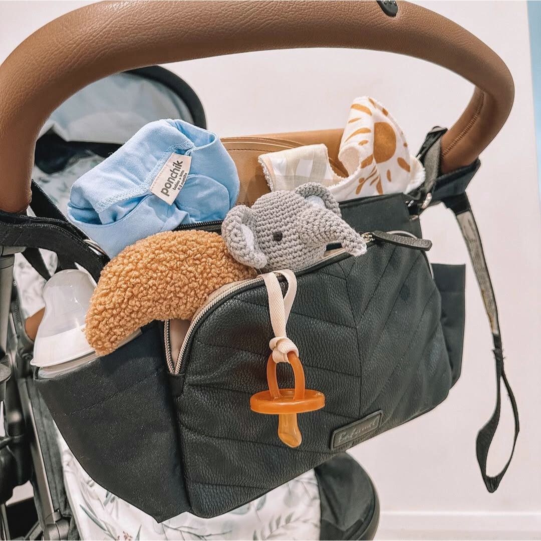 Babymel Quilted pram caddy packed with baby essentials - lifestyle image