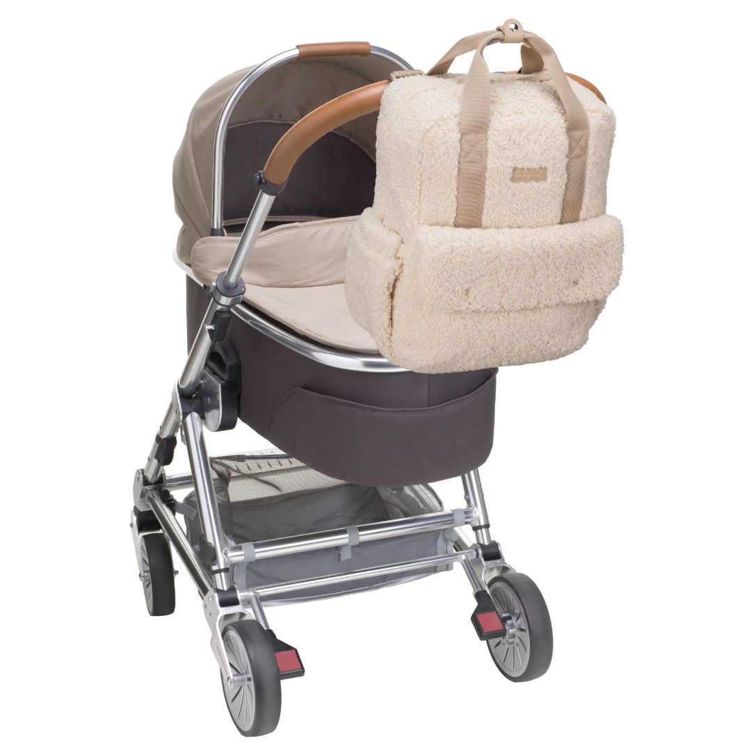 Babymel Teddy Cream Nappy Backpack stylishly attached to a stroller, perfect for chic parenting and baby outings.
