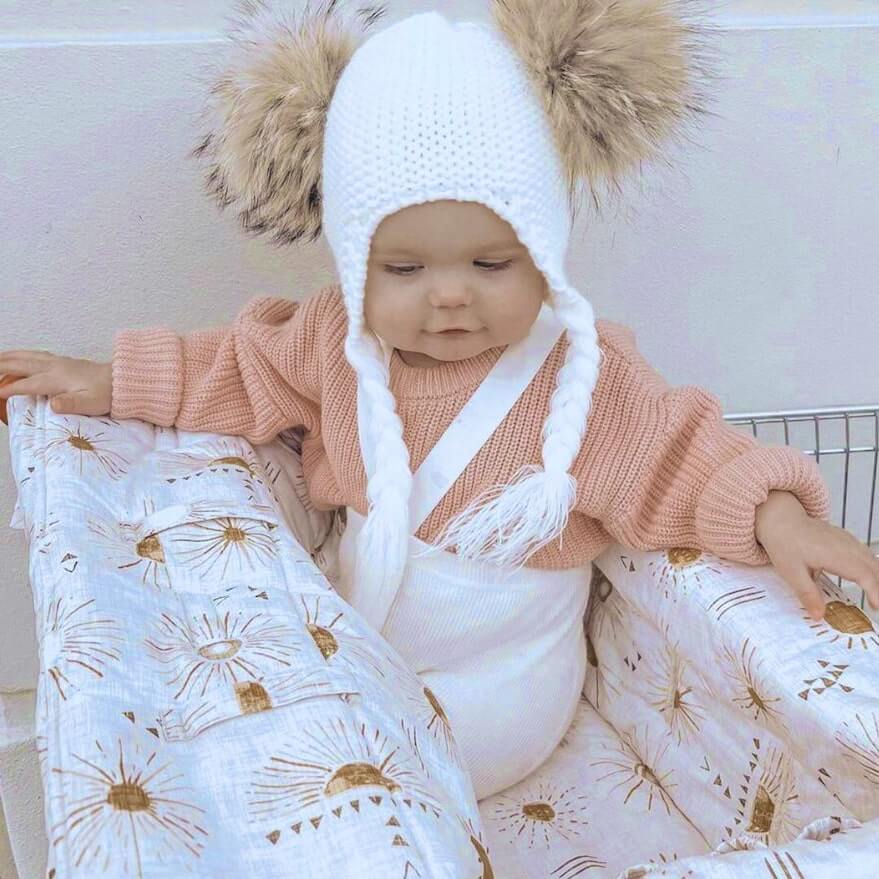 Baby girl wearing our pink chunky knitted jumper with white suspender tights