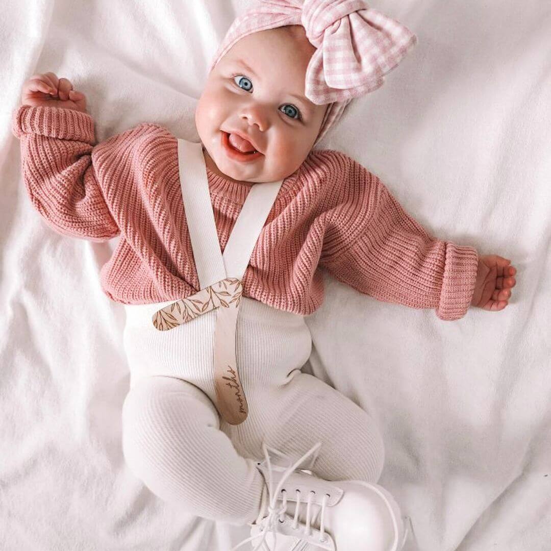 Baby girl wearing our rose knitted jumper with suspender tights