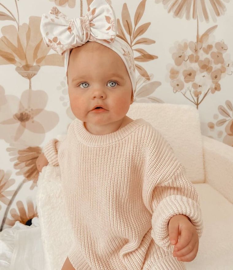 Cute baby girl wearing our chunky knitted jumper in beige