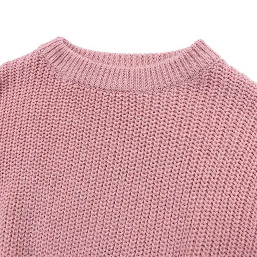 Closeup of knitted baby jumper in rose colour