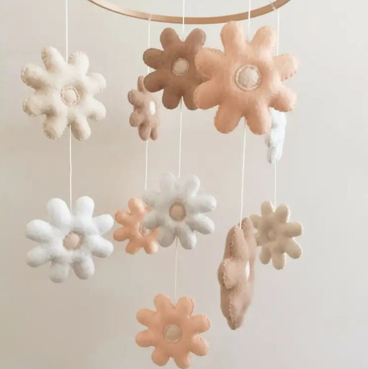 Daisy baby cot mobile featuring soft felt flowers in neutral tones for nursery decor, adding charm to baby's space.