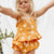 Girl wearing yellow daisy toddler girl outfit - peplum top and matching shorts