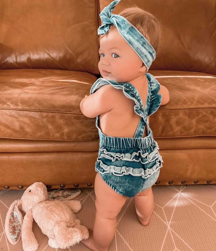 Baby girl standing, wearing Denim Ruffle Rainbow Romper - Lulu Babe