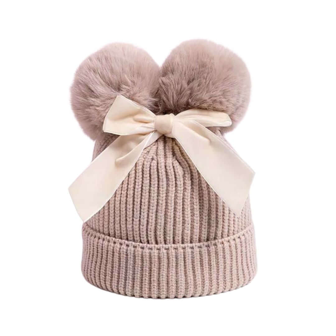 Pink knit beanie with two fluffy pom-poms and a large pink velvet bow