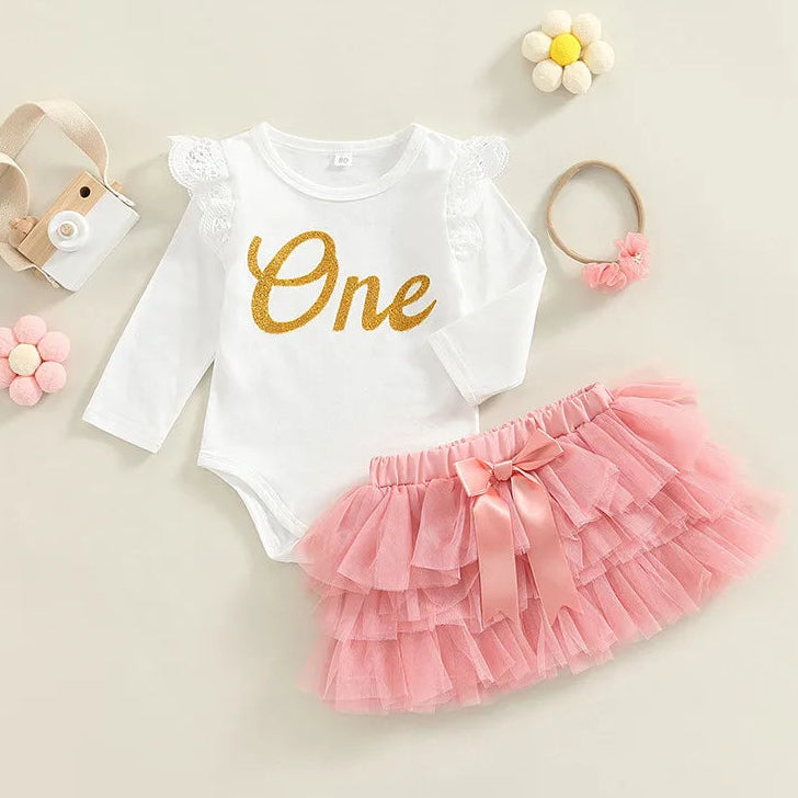 Baby girl first birthday outfit sit with "One" long-sleeve bodysuit and pink tutu skirt