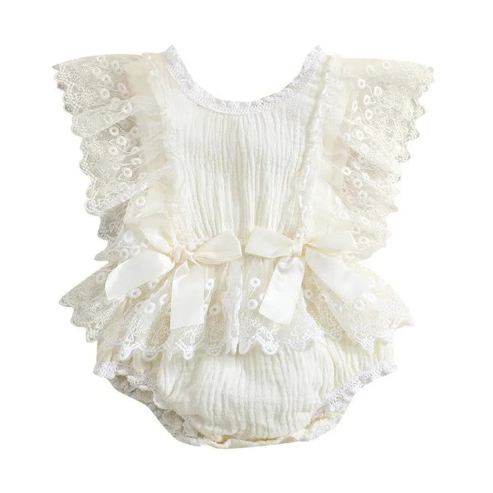 Ivory lace baby romper featuring ruffled lace sleeves, a gathered crinkle fabric body, and multiple satin bows with lace trim