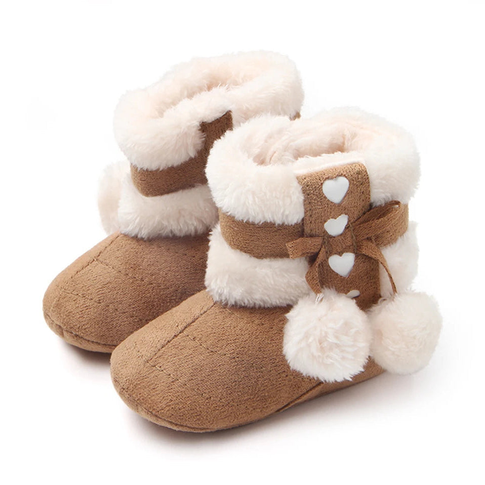 Adorable heart slipper boots for babies in brown, featuring plush fur lining and cute pom poms, perfect for keeping little feet warm.