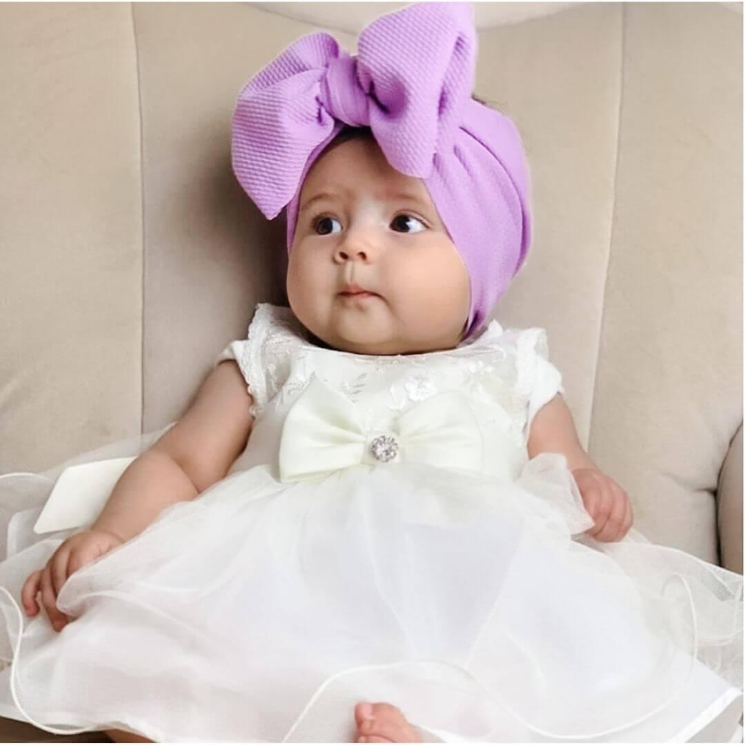 Baby girl wearing purple bow headband from Lulu Babe
