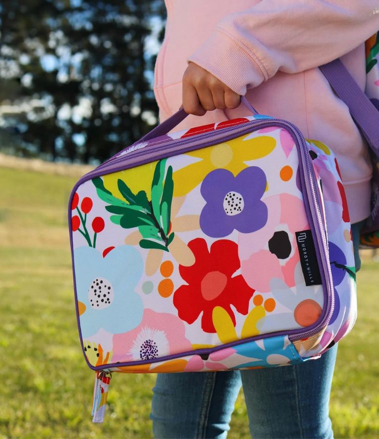Child holding Morgy + Wills Bloom floral insulated lunch bag outdoors