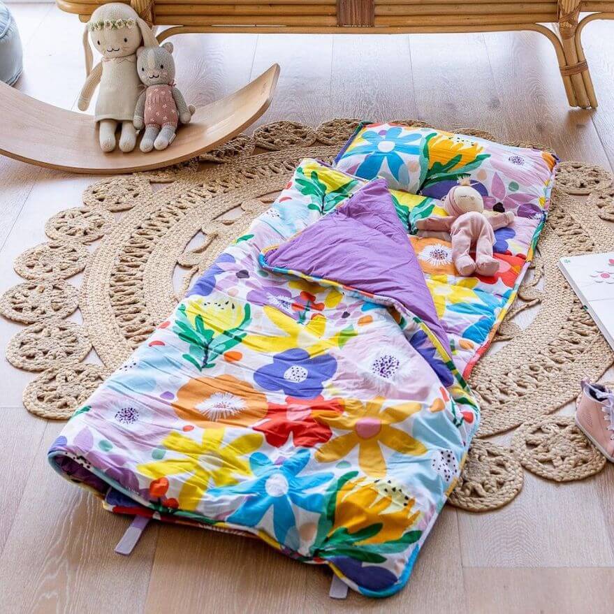 All-in-one toddler nap mat with attached blanket and removable pillow in vivid floral print