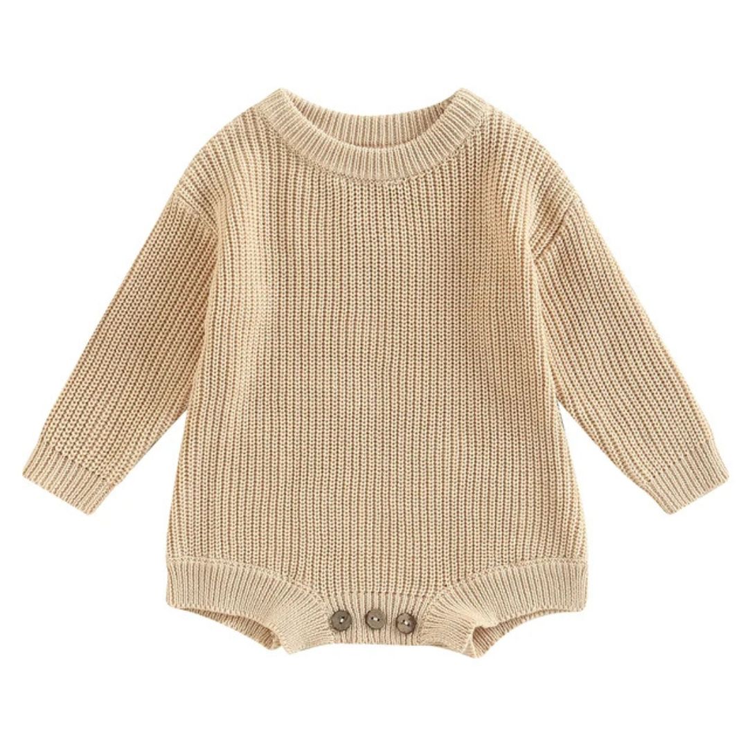Chunky knit baby romper in beige with long sleeves and button closure, perfect winter essential for comfort and style.