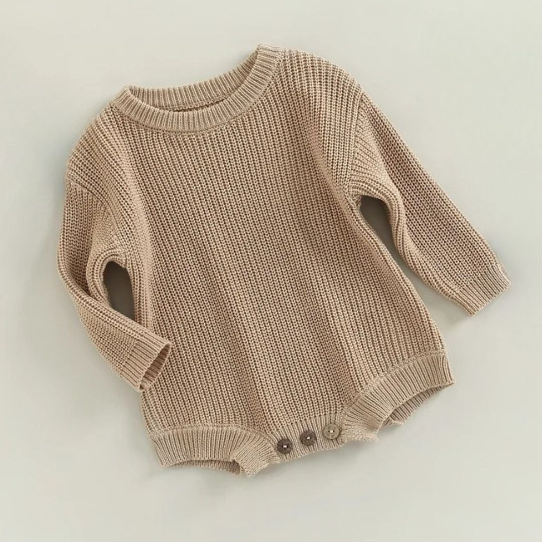 Knitted baby romper in latte, perfect winter outfit for babies, with long sleeves and button closures.