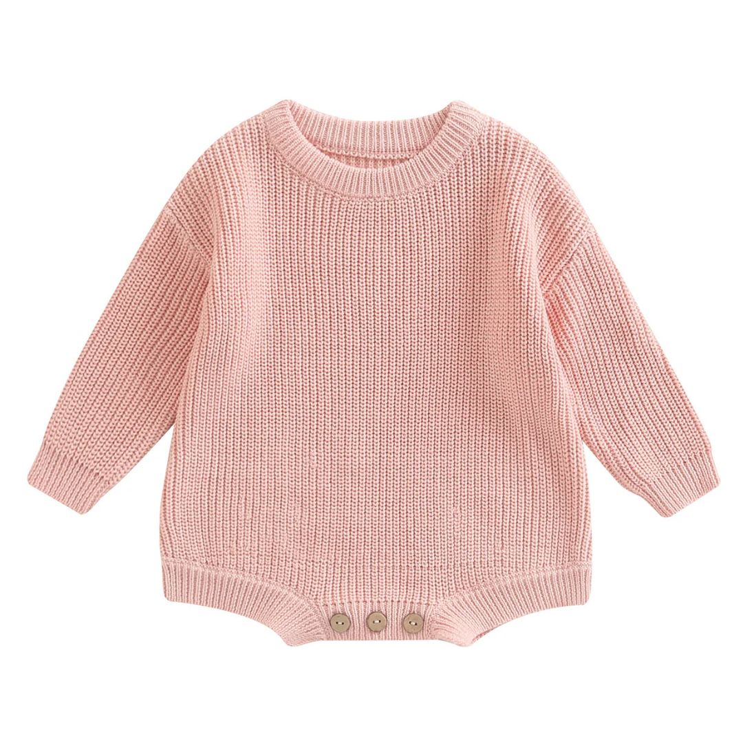 Chunky knit baby romper in soft pink with long sleeves and button detailing for winter warmth and style.