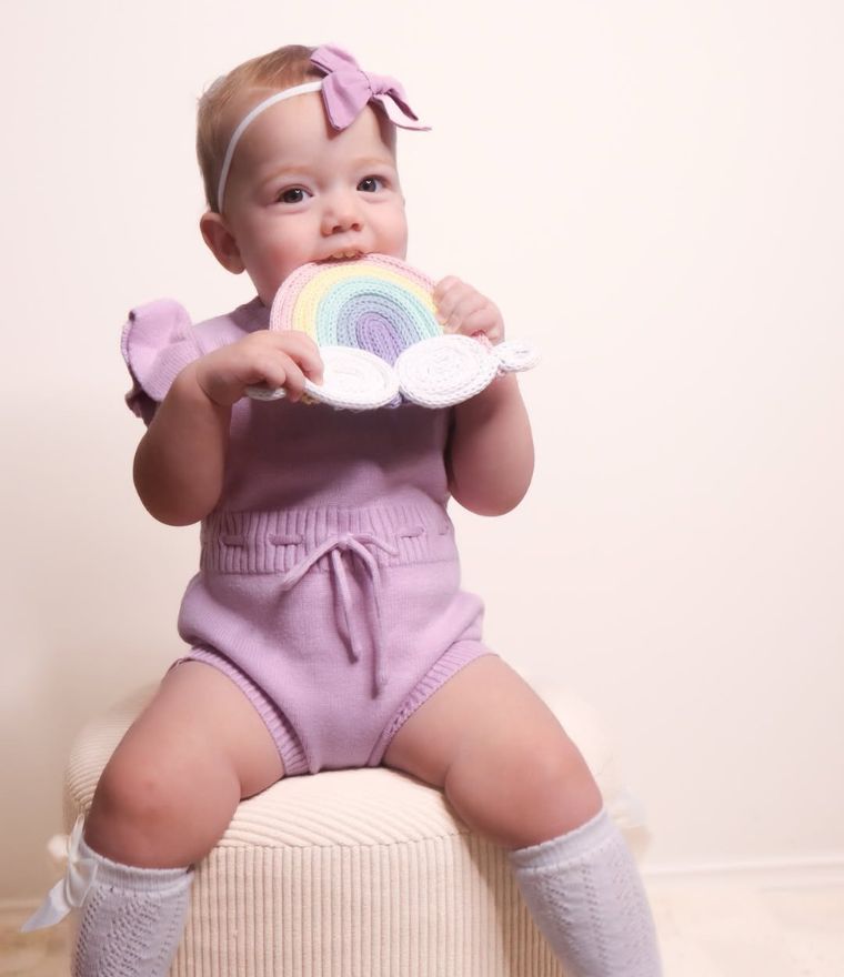 Baby girl wearing purple ruffle knit baby romper from Lulu Babe