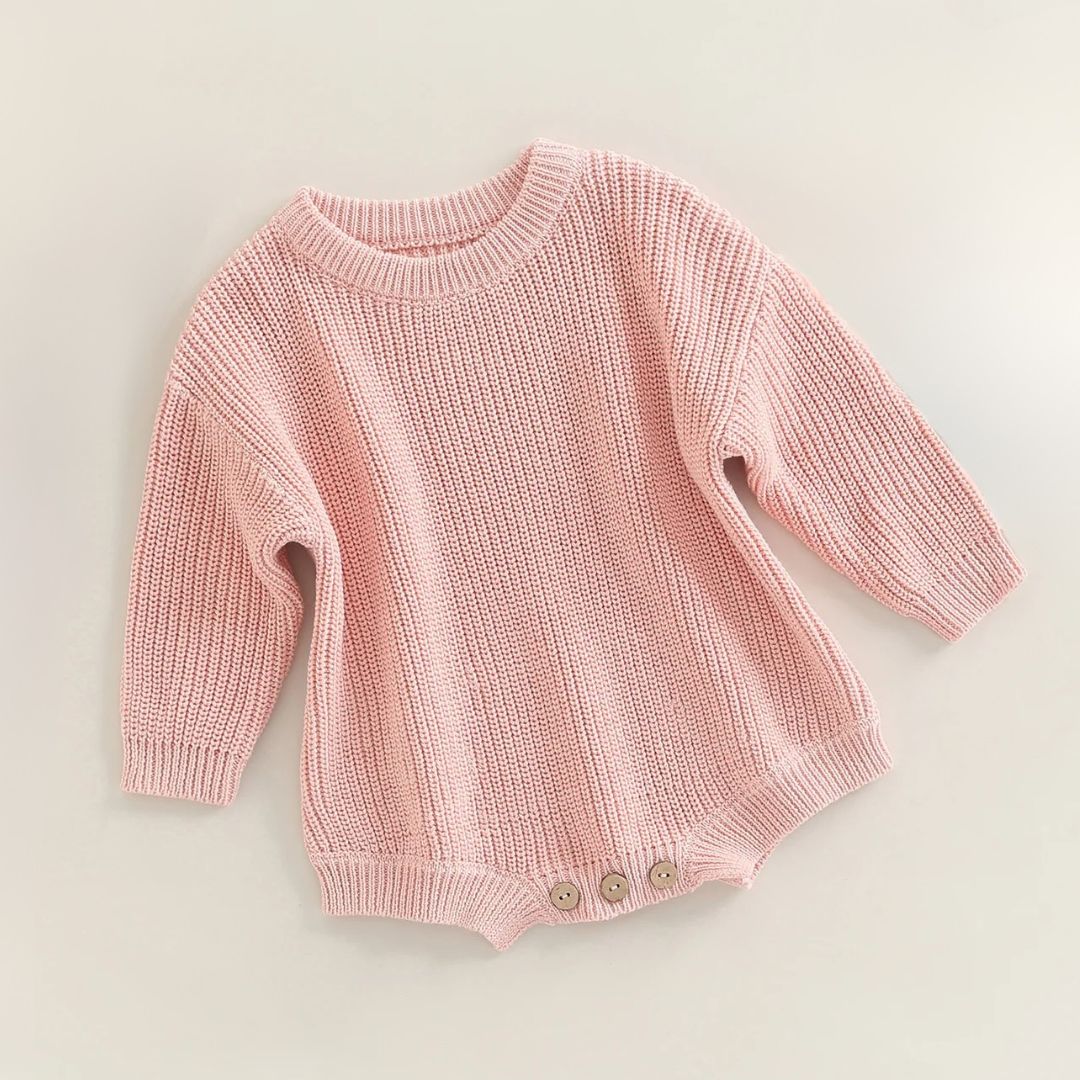 Cute pink chunky knit baby romper with long sleeves, ideal for winter comfort and style.